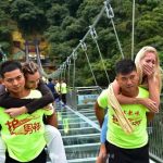 玻璃橋上的新職業,大家稱他們為「護玻男神」專門背女遊客過橋的